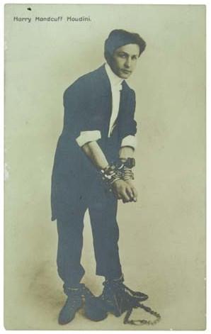 A real photo postcard of a shackled Harry Houdini, titled "Harry Handcuff Houdini"