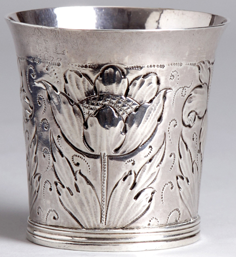 A 17th century English silver beaker with embossed flowers and leaf decoration