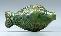 A two-sided Moravian fish flask, green-glazed cream-colored earthenware, molded with scales, fins and eyes, attributed to Rudolph Christ, Salem, North Carolina, early 19th century.