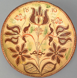 A Conrad Mumbauer, attributed (1761 to 1845), Haycock Township, Bucks County, Pennsylvania, glazed sgraffito redware plate dated "1810"