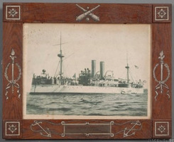 An early 20th century painted sheet iron frame made from remnants of the battleship Maine with photograph