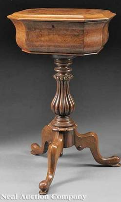 An English [William IV] carved and burled walnut teapoy, circa 1840, octagonal hinged top opening to fitted interior with lidded tea compartments, mixing bowl not present, reeded vasiform pedestal, tripod cabriole legs.