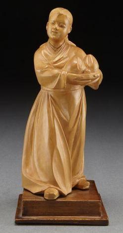 A circa 1960 Chinese Cultural Revolution carved boxwood figure, depicting a Mongolian girl holding two peaches.
