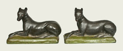 A very rare and important pair of Shenandoah Valley redware [dog figures depicting] whippets, both signed Samuel Bell / Winchester Sept 21 1841, Winchester, Virginia origin, matched pair of molded redware whippet figures with incised details to face and paws, both dogs painted black with white-and-red eyes and red mouths, reclining atop green-painted bases with incised borders.